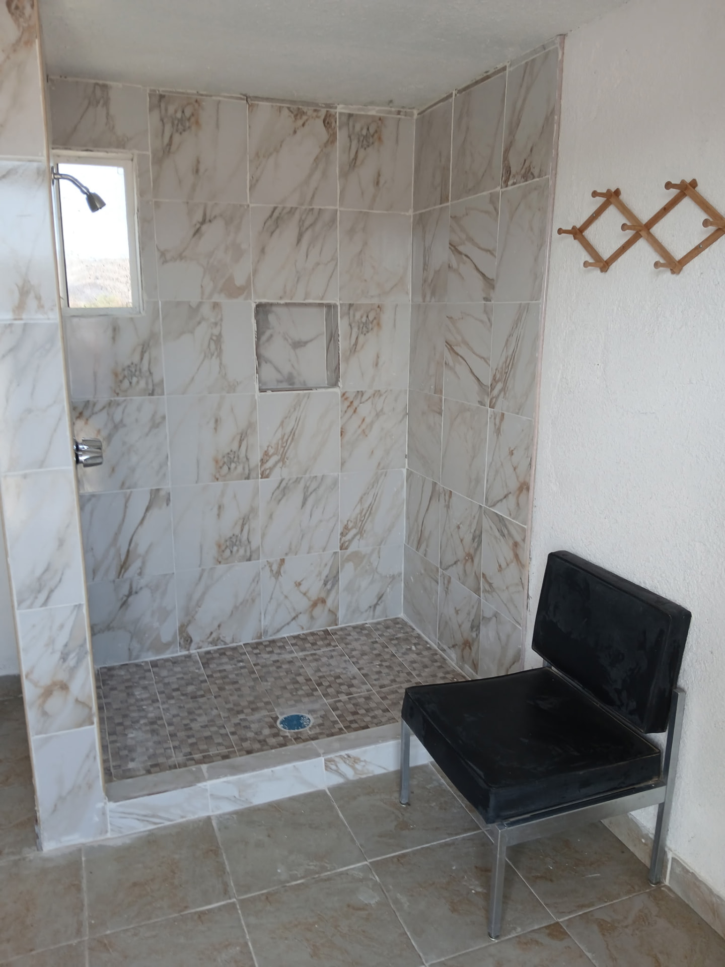 Tiled walk-in shower with bench inside the guest bathhouse